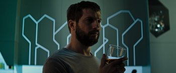 Movie still from “Upgrade” (2018), directed by Leigh Whannell – A bearded man holding a glass of wine; Close Up shot, Low angle