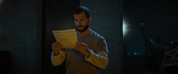 Movie still from “Upgrade” (2018), directed by Leigh Whannell – A man holding a piece of paper while standing in a dark room; Close Up shot, Low angle