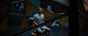 Movie still from “Upgrade” (2018), directed by Leigh Whannell – A man sitting on top of a wooden stool; Wide shot, High angle