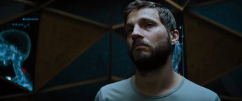 Movie still from “Upgrade” (2018), directed by Leigh Whannell – A man with a goatee and a beard looking to his left; Close Up shot, Low angle