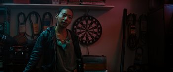 Movie still from “Upgrade” (2018), directed by Leigh Whannell – A woman standing in front of a dartboard; Close Up shot, Over the shoulder angle