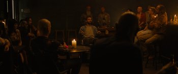 Movie still from “Upgrade” (2018), directed by Leigh Whannell – A man sitting in front of a candle in a dark room; Wide shot, Over the shoulder angle
