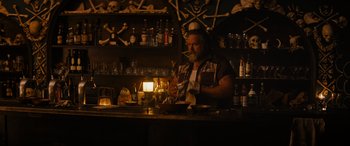 Movie still from “Upgrade” (2018), directed by Leigh Whannell – A man sitting at a bar in a dark room; Medium shot, Over the shoulder angle