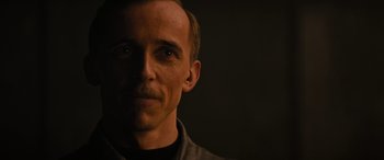 Movie still from “Upgrade” (2018), directed by Leigh Whannell – A person wearing a black shirt; Close Up shot, Over the shoulder angle