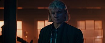 Movie still from “Upgrade” (2018), directed by Leigh Whannell – A person with a white hair and a black jacket; Close Up shot, Low angle