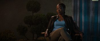 Movie still from “Upgrade” (2018), directed by Leigh Whannell – A woman sitting on a chair in the dark; Medium shot, Over the shoulder angle