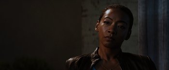 Movie still from “Upgrade” (2018), directed by Leigh Whannell – A woman wearing a brown leather jacket looking at the camera; Close Up shot, Low angle