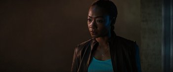 Movie still from “Upgrade” (2018), directed by Leigh Whannell – A black woman wearing a leather jacket looking at the camera; Close Up shot, Low angle