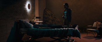 Movie still from “Upgrade” (2018), directed by Leigh Whannell – A man and a woman in a room with a bed; Wide shot, High angle