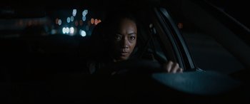 Movie still from “Upgrade” (2018), directed by Leigh Whannell – A woman sitting in the driver's seat of a car at night; Close Up shot, Over the shoulder angle