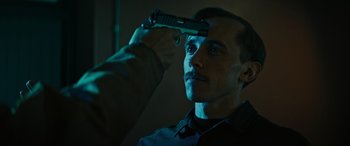 Movie still from “Upgrade” (2018), directed by Leigh Whannell – A man holding a gun up to his head; Close Up shot, Over the shoulder angle