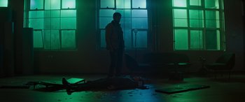Movie still from “Upgrade” (2018), directed by Leigh Whannell – A man standing in a room with a broken window; Wide shot, Low angle