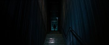 Movie still from “Upgrade” (2018), directed by Leigh Whannell – A person walking down a set of stairs at night; Extreme Wide shot, Low angle
