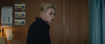 Movie still from “Upgrade” (2018), directed by Leigh Whannell – A man with blonde hair and blue eyes wearing a black jacket; Close Up shot, Low angle