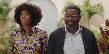 Movie still from “Vacation Friends” (2021), directed by Clay Tarver – A man and a woman standing next to each other in front of an archway; Medium shot, Over the shoulder angle