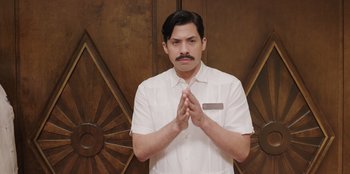 Movie still from “Vacation Friends” (2021), directed by Clay Tarver – A man in a white dress shirt and tie; Medium shot, Low angle