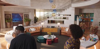 Movie still from “Vacation Friends” (2021), directed by Clay Tarver – A living room filled with couches and a table; Extreme Wide shot, High angle