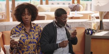 Movie still from “Vacation Friends” (2021), directed by Clay Tarver – A man and a woman sitting next to each other; Medium shot, Over the shoulder angle