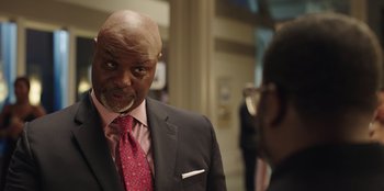 Movie still from “Vacation Friends” (2021), directed by Clay Tarver – A man in a suit and tie looking into a mirror; Close Up shot, Over the shoulder angle