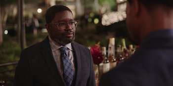 Movie still from “Vacation Friends” (2021), directed by Clay Tarver – A man in a suit and tie talking to a man in a suit and tie; Close Up shot, Over the shoulder angle