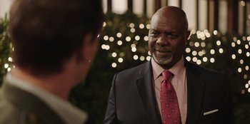 Movie still from “Vacation Friends” (2021), directed by Clay Tarver – A man wearing a suit and tie talking to another man; Close Up shot, Over the shoulder angle