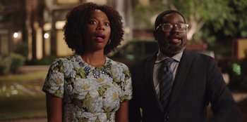 Movie still from “Vacation Friends” (2021), directed by Clay Tarver – A man and a woman standing next to each other; Medium shot, Over the shoulder angle