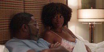 Movie still from “Vacation Friends” (2021), directed by Clay Tarver – A man and a woman sitting next to each other on a couch; Medium shot, Over the shoulder angle