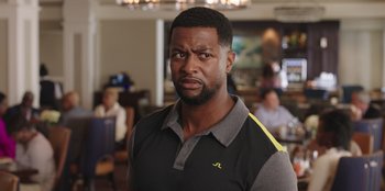 Movie still from “Vacation Friends” (2021), directed by Clay Tarver – A person wearing a polo shirt; Close Up shot, Over the shoulder angle