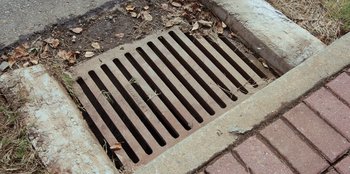Movie still from “Vacation Friends” (2021), directed by Clay Tarver – A metal grate on the ground; Extreme Close Up shot, Overhead angle