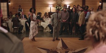 Movie still from “Vacation Friends” (2021), directed by Clay Tarver – A group of people standing in a room; Wide shot, Over the shoulder angle