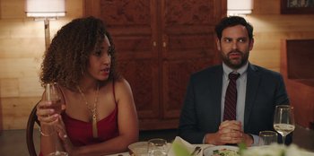 Movie still from “Vacation Friends” (2021), directed by Clay Tarver – A man and a woman sitting at a dinner table; Medium shot, Over the shoulder angle