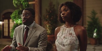 Movie still from “Vacation Friends” (2021), directed by Clay Tarver – A man and a woman standing next to each other; Medium shot, Over the shoulder angle