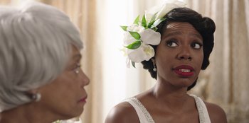 Movie still from “Vacation Friends” (2021), directed by Clay Tarver – A woman wearing a white flower in her hair; Close Up shot, Over the shoulder angle