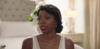 Movie still from “Vacation Friends” (2021), directed by Clay Tarver – A woman with a flower in her hair looking angry; Close Up shot, Over the shoulder angle