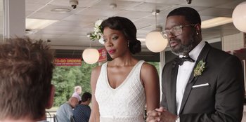 Movie still from “Vacation Friends” (2021), directed by Clay Tarver – A man and a woman standing next to each other; Medium shot, Over the shoulder angle