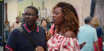 Movie still from “Vacation Friends 2” (2023), directed by Clay Tarver – A man and a woman standing next to each other; Medium shot, Over the shoulder angle