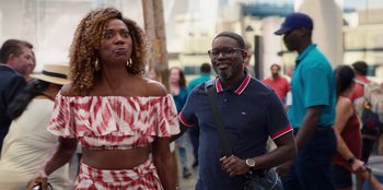 Movie still from “Vacation Friends 2” (2023), directed by Clay Tarver – A man and a woman standing next to each other on the street; Medium shot, Over the shoulder angle