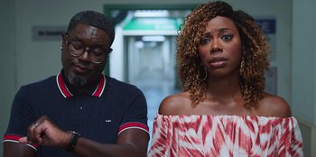 Movie still from “Vacation Friends 2” (2023), directed by Clay Tarver – A man and a woman standing next to each other; Medium shot, Over the shoulder angle