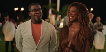 Movie still from “Vacation Friends 2” (2023), directed by Clay Tarver – A man and a woman standing next to each other; Medium shot, Over the shoulder angle