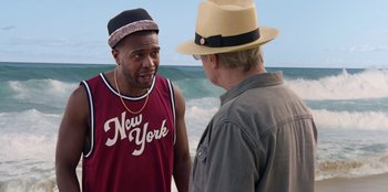 Movie still from “Vacation Friends 2” (2023), directed by Clay Tarver – Two men standing on the beach talking to each other; Medium shot, Over the shoulder angle