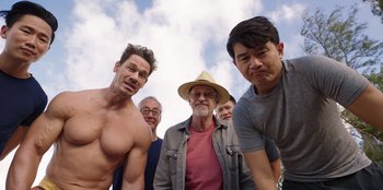 Movie still from “Vacation Friends 2” (2023), directed by Clay Tarver – A group of men standing next to each other in front of a cloudy sky; Medium shot, Low angle