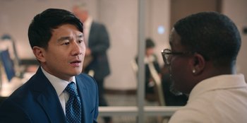 Movie still from “Vacation Friends 2” (2023), directed by Clay Tarver – A man wearing a suit and tie talking to another man wearing glasses; Close Up shot, Over the shoulder angle