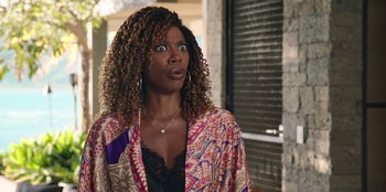 Movie still from “Vacation Friends 2” (2023), directed by Clay Tarver – A person with a surprised look on their face; Close Up shot, Over the shoulder angle