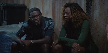 Movie still from “Vacation Friends 2” (2023), directed by Clay Tarver – A man and a woman sitting next to each other; Medium shot, High angle