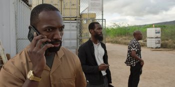 Movie still from “Vacation Friends 2” (2023), directed by Clay Tarver – A group of men standing next to each other on a dirt road; Close Up shot, Over the shoulder angle