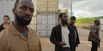 Movie still from “Vacation Friends 2” (2023), directed by Clay Tarver – A group of men standing next to each other in a field; Close Up shot, Over the shoulder angle