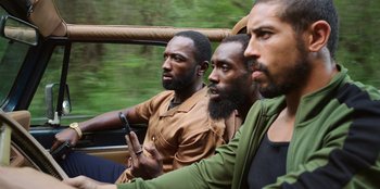 Movie still from “Vacation Friends 2” (2023), directed by Clay Tarver – A group of men sitting in the back of a truck; Medium shot, High angle