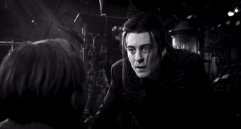 Movie still from “Van Helsing” (2004), directed by Stephen Sommers – A man with long black hair is looking at the camera; Close Up shot, Over the shoulder angle