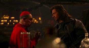 Movie still from “Van Helsing” (2004), directed by Stephen Sommers – A man and a man in a black leather jacket talking to each other; Medium shot, Over the shoulder angle