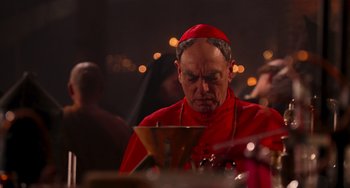 Movie still from “Van Helsing” (2004), directed by Stephen Sommers – A man in a red robe is looking down at a candle; Close Up shot, Over the shoulder angle